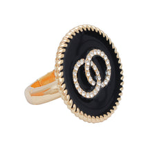 Load image into Gallery viewer, Side-angle view of a black epoxy ring with clear rhinestone interlocking circles and a gold-tone band on white
